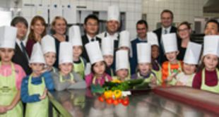 Gruppenbild in Hotelküche mit Kindern mit Kochmützen