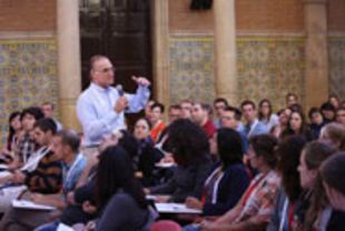 Prof. Ron Kahn mit Mikrofon in den Zuhörerreihen in der Casa Convalescencia der Uni Barcelona